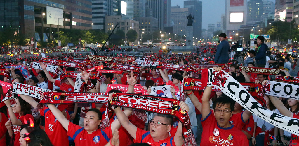 A packed stand of South Korea supporters waving Taegukgi flags